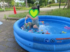 プールでおもちゃの魚すくいをする写真