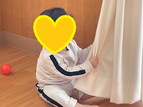 いないいないばぁをする赤ちゃんの写真