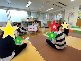「だるまさんが」の絵本を楽しむ親子の写真
