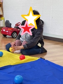 パラバルーンの上にボールを乗せて遊ぶ写真