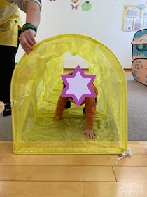 トンネル遊びをする幼児の写真