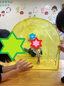 トンネル遊びをする幼児の写真