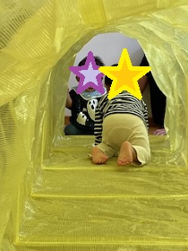 トンネル遊びをする幼児の写真