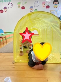 トンネル遊びをする幼児の写真