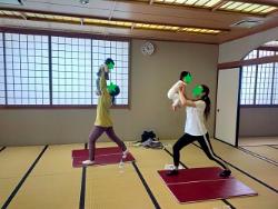 ヨガポーズで子供を持ち上げている