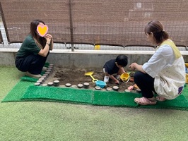 砂場で遊ぶ親子と先生