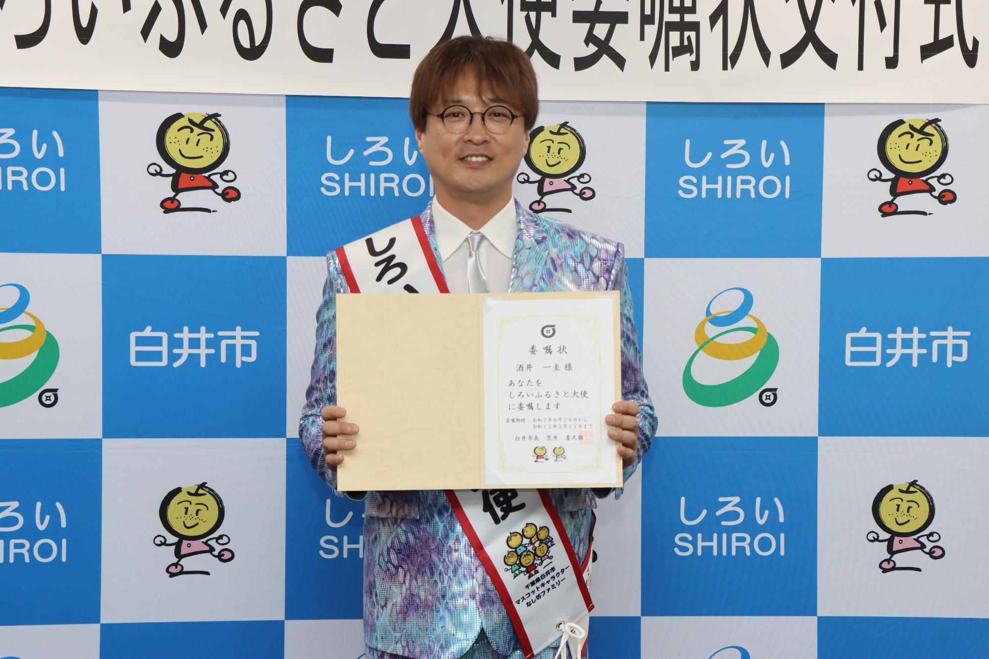 酒井さんが委嘱状をもっている写真