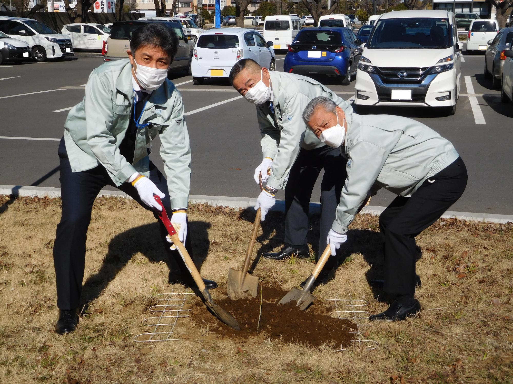 苗木に土をかける副市長、市長、教育長