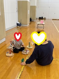 輪投げゲームで遊ぶママと子どもの写真