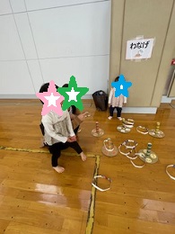 輪投げゲームで遊ぶママと子どもの写真その2