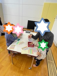 クリスマスツリーの制作をする一家の笑顔の写真