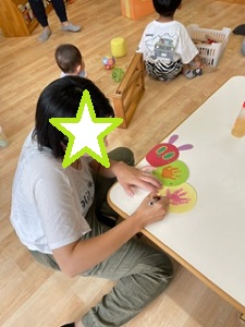 手形を並べてはらぺこ青虫の手形アートを作っている写真