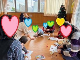 サンタさんのオーナメントを作る親子の写真