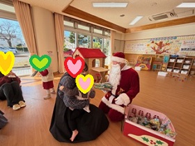 サンタさんからプレゼントをもらう母子の写真