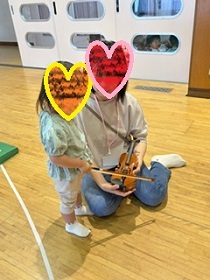 楽器に触れて楽しむ親子の写真