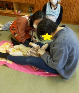 寝転んで歯磨きされるこども