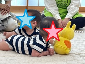 ボランティアさんと遊ぶ双子の赤ちゃんの写真