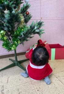 クリスマスツリーの飾りを持つ子どもの写真
