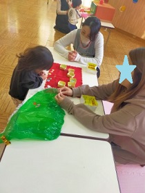 ビニールマントにシールを貼る女の子