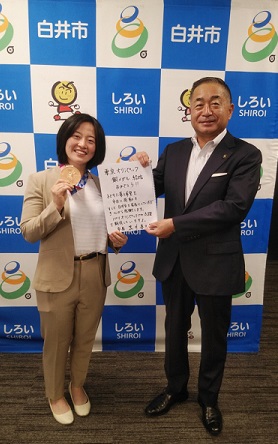 市民等から安藤選手への激励の言葉が書かれたスケッチブックを贈呈する様子