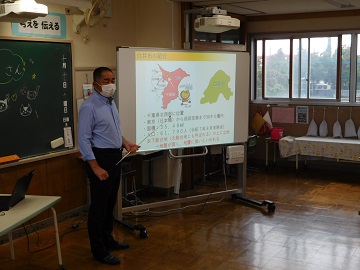 ホワイトボードへ投資した資料を使用し授業を行う様子